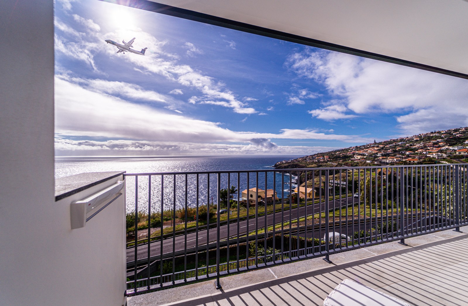 Ocean and airport view with an aircraft over the sea from the balcony at Guesthouse Olival, Madeira