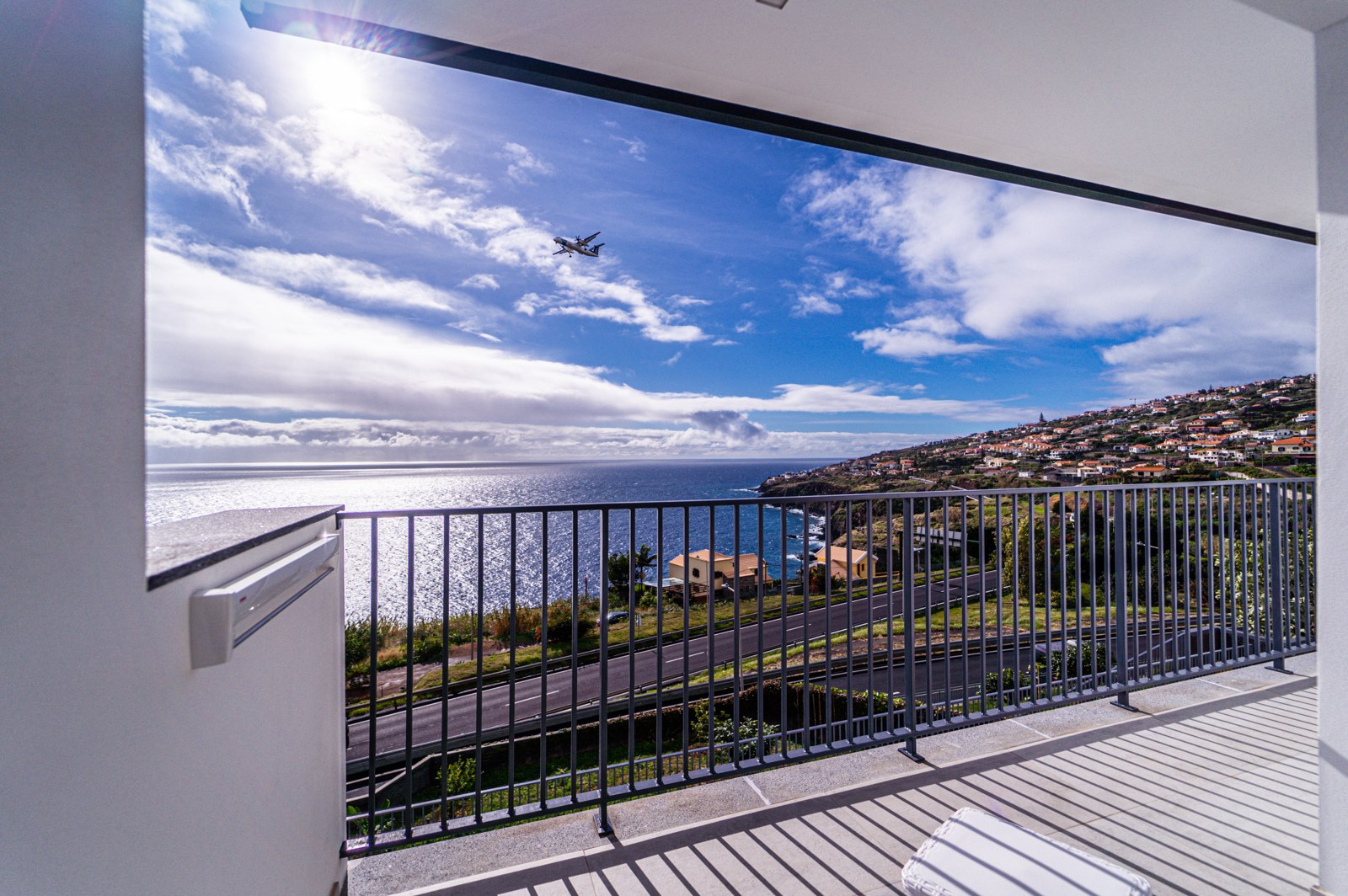 Balcony view of the ocean and coastline with a plane approaching Madeira airport, Guesthouse Olival