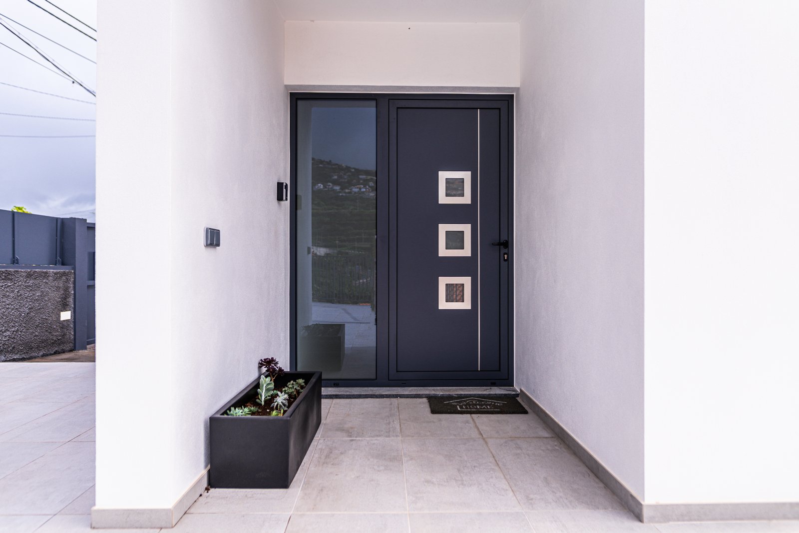 Private apartment entrance door with a Welcome Home mat at Guesthouse Olival, Gaula, Madeira