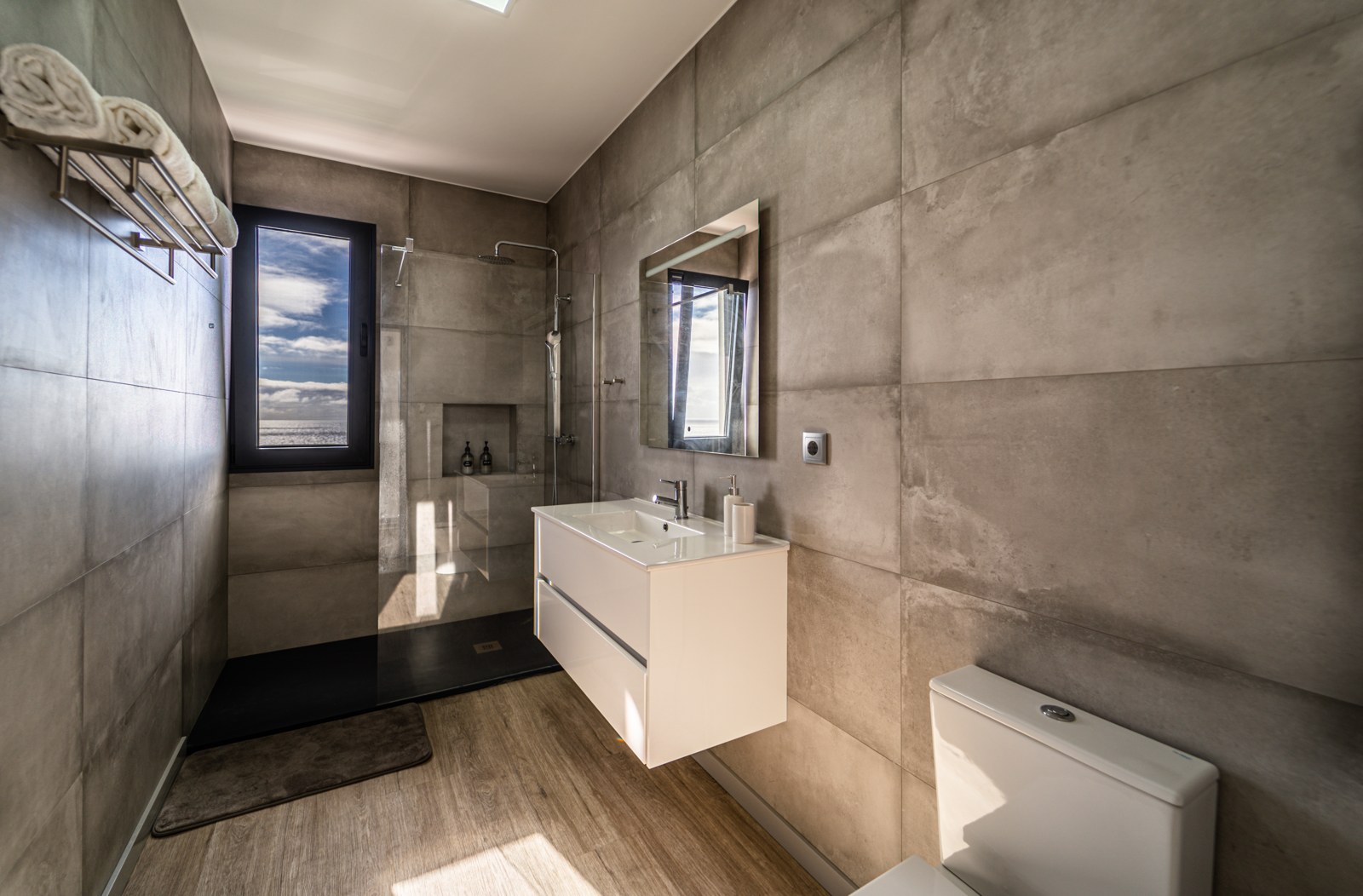 Modern bathroom with walk-in shower, vanity and sea-view window at Guesthouse Olival, Madeira