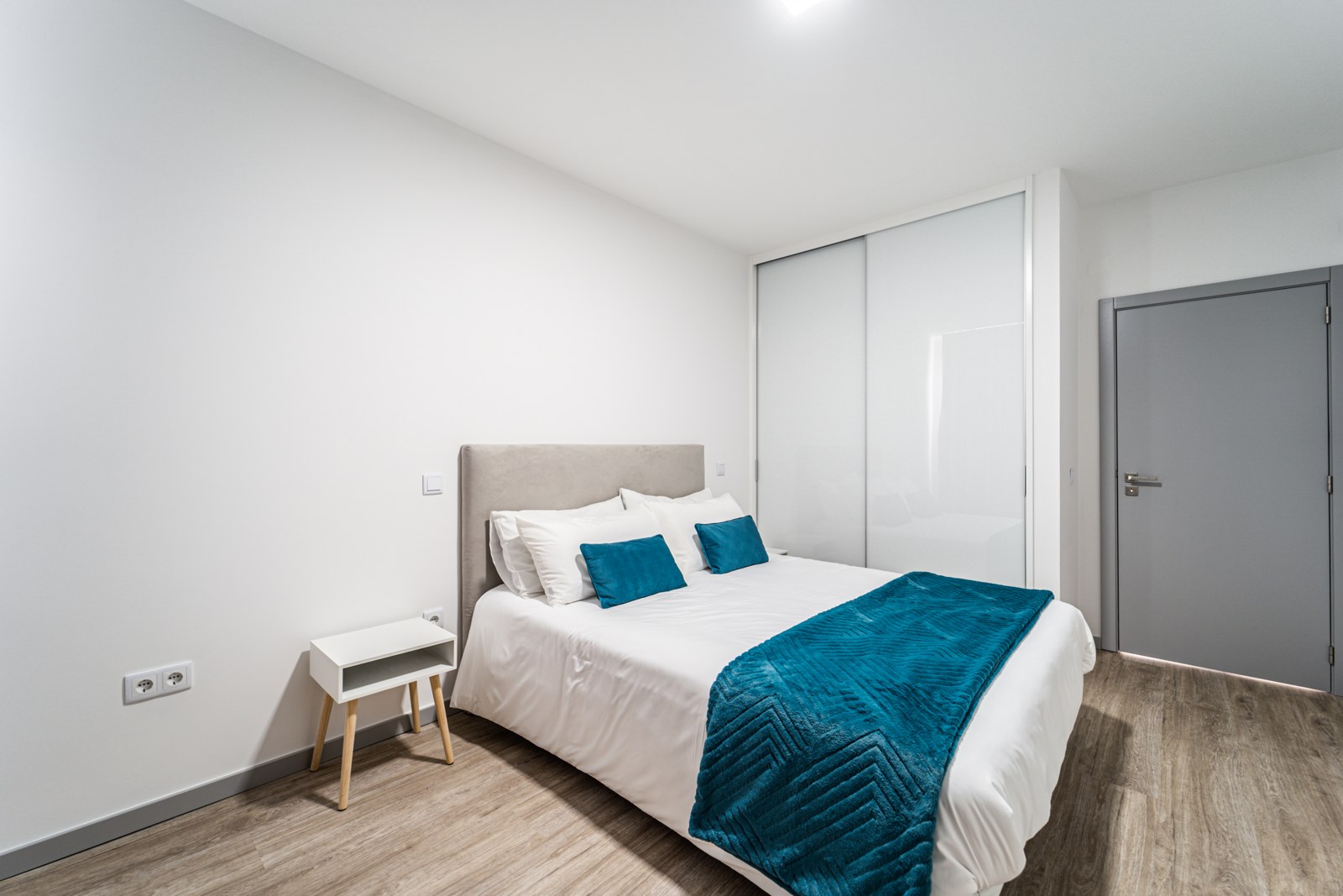Bedroom with king bed and large mirrored wardrobe at Guesthouse Olival, Madeira