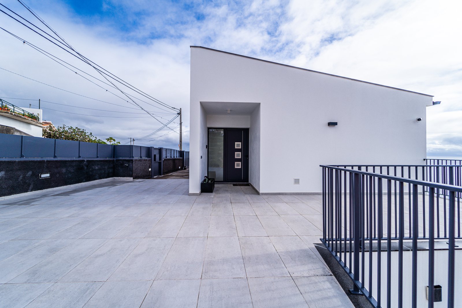 White modern apartment building and tiled forecourt at Guesthouse Olival, Gaula, Madeira