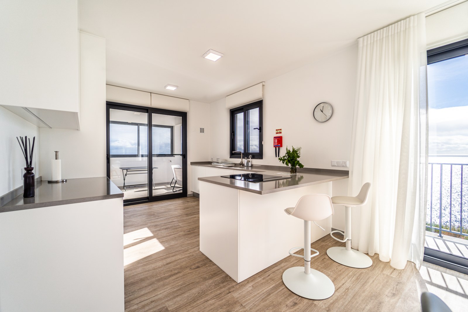 Bright open kitchen with induction hob, breakfast bar and sea view at Guesthouse Olival, Madeira