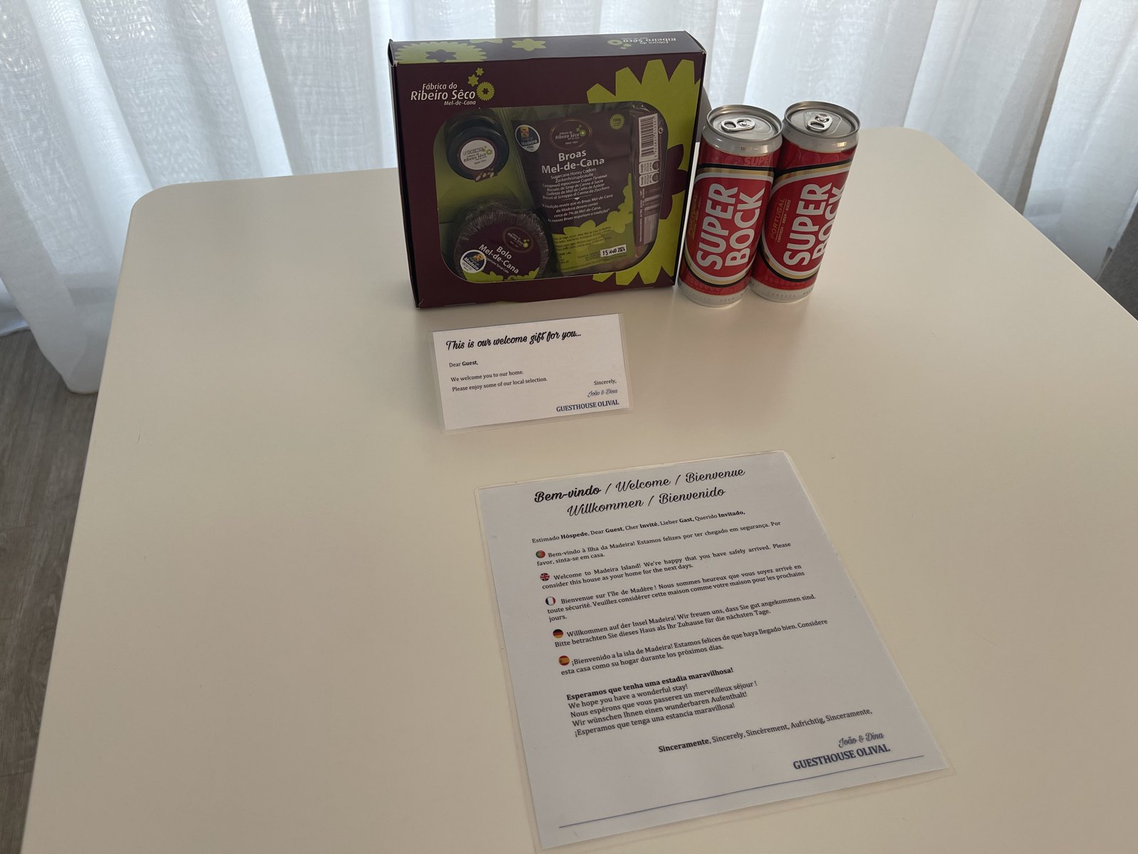 Welcome gift, drinks and house-information leaflet on the dining table at Guesthouse Olival, Madeira