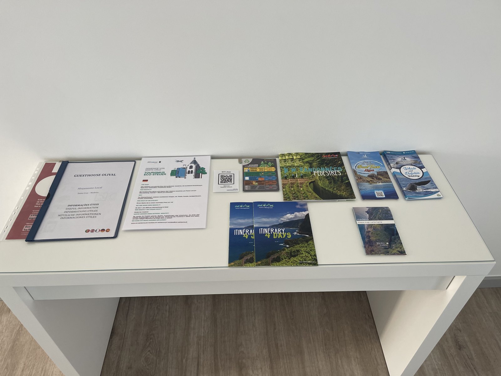Desk with the welcome binder and Madeira tourist guides and brochures at Guesthouse Olival